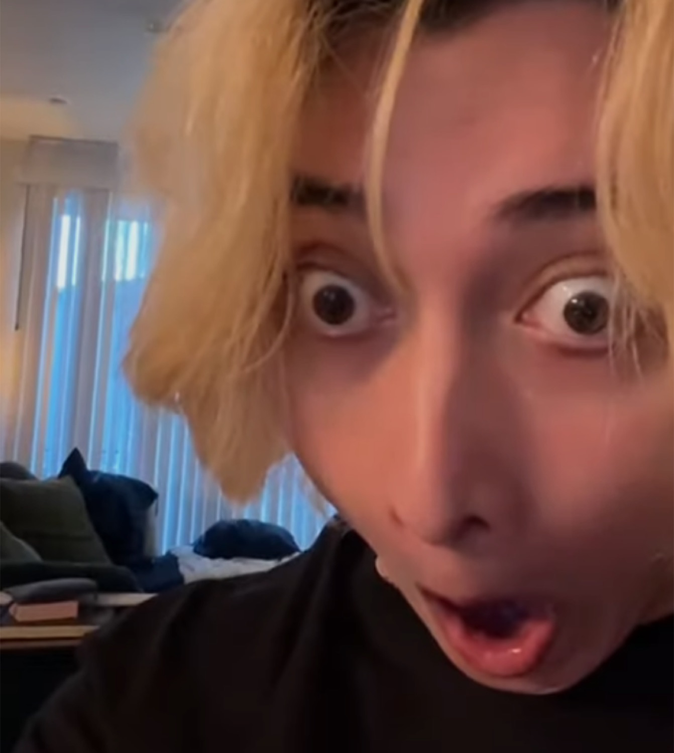 Blond guy in a dim room with wide eyes and a dropped jaw, totally shook