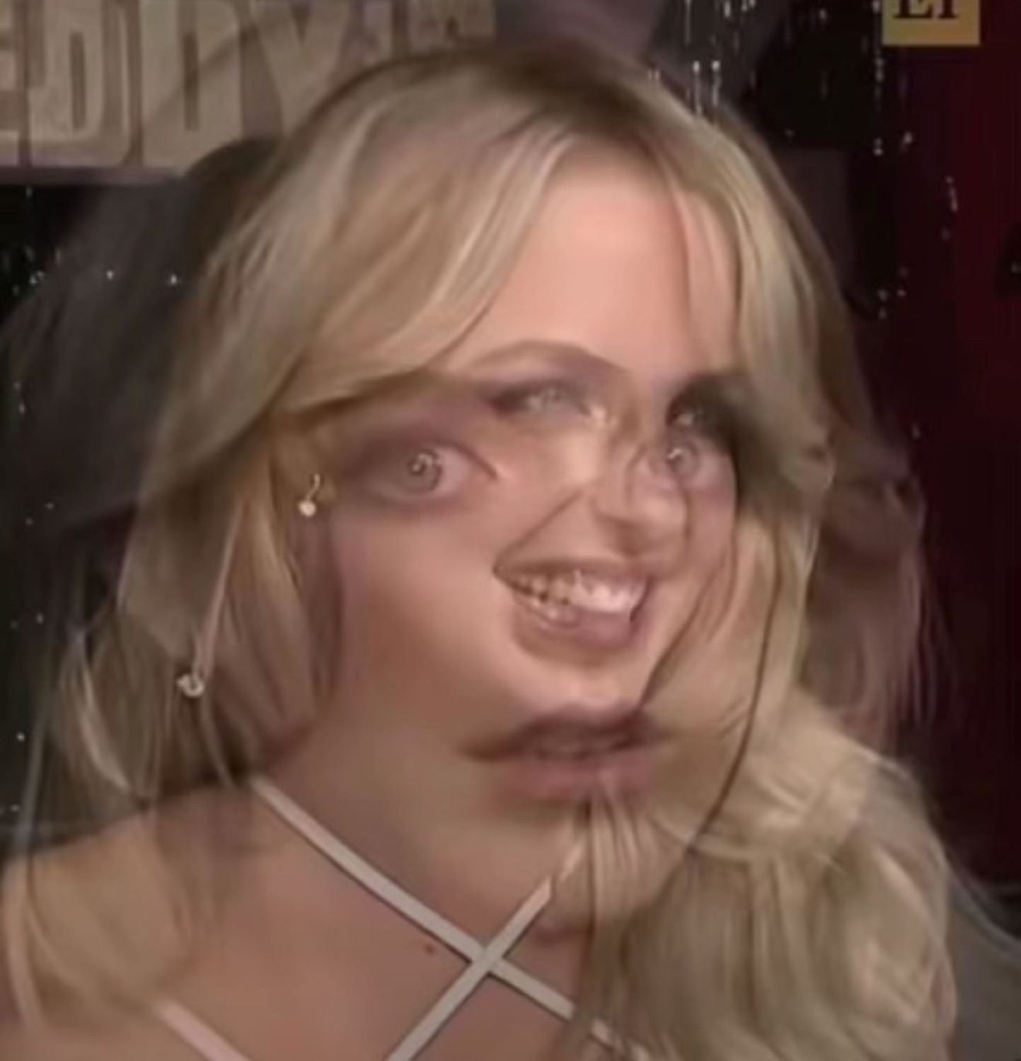Blonde woman caught mid-blink with a warped, goofy grimace on a distorted freeze-frame