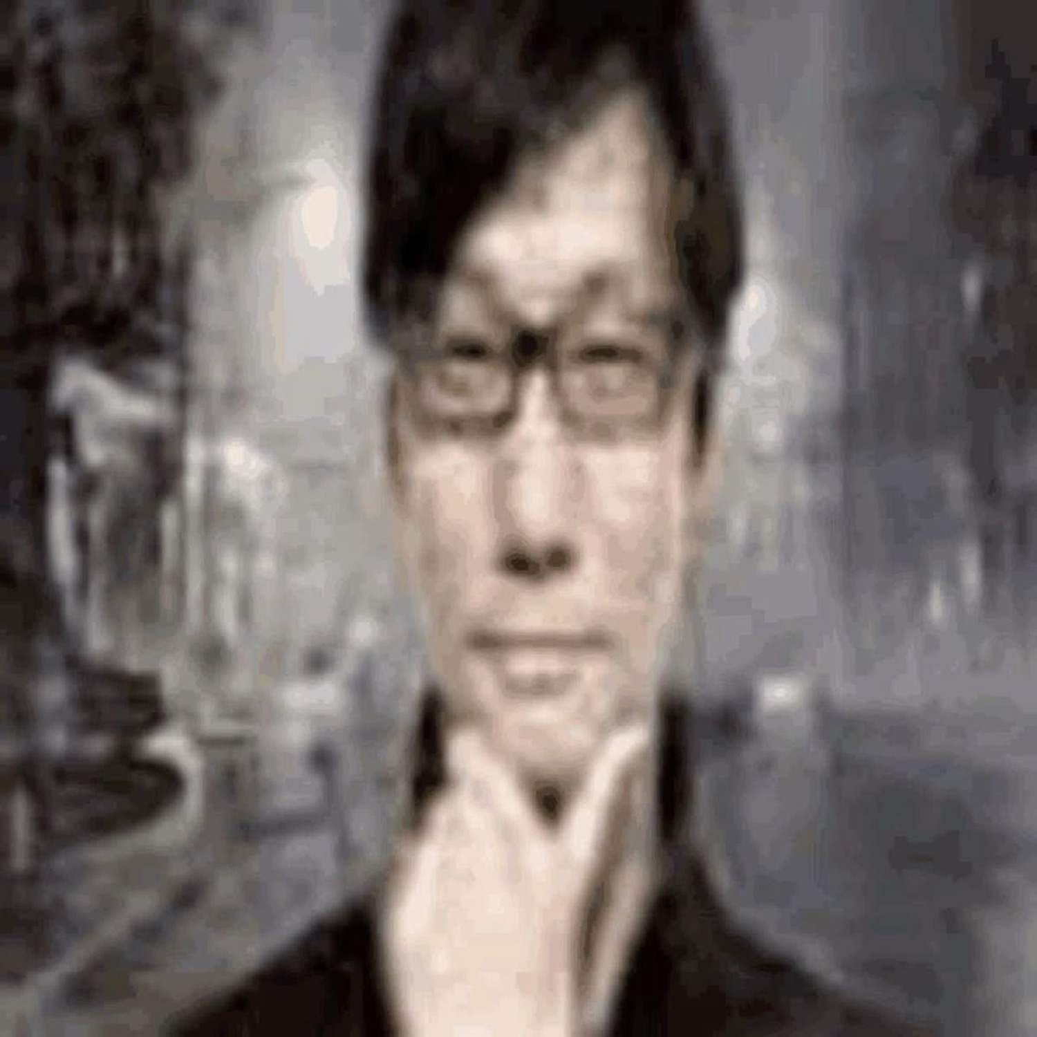Grainy black-and-white photo of a man in glasses staring straight ahead with a flat, deadpan face