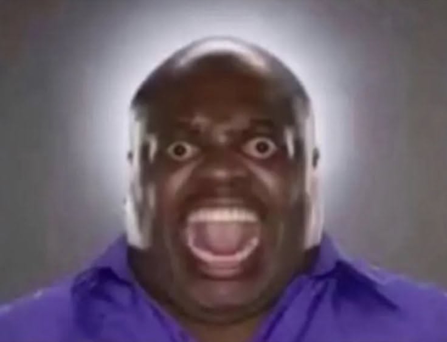 Bald man in a purple shirt screaming with wide eyes and mouth fully open