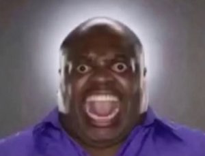Bald man in a purple shirt screaming with wide eyes and mouth fully open