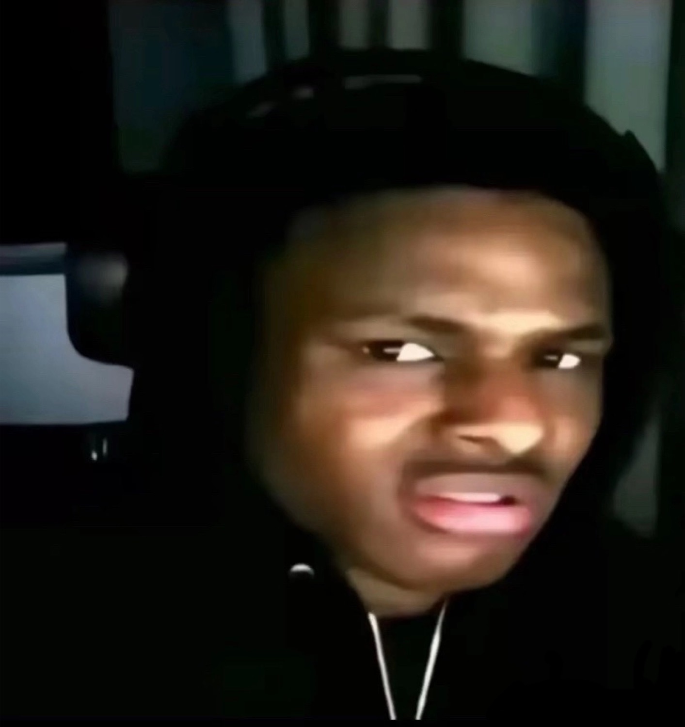 Guy in a black hoodie staring sideways with glowing eyes and a knowing smirk
