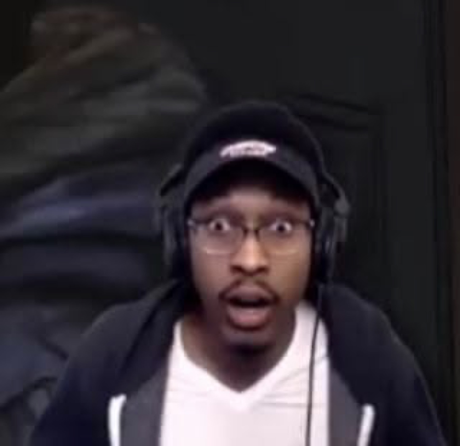 Guy in a cap and headphones with mouth open and eyes wide in total shock