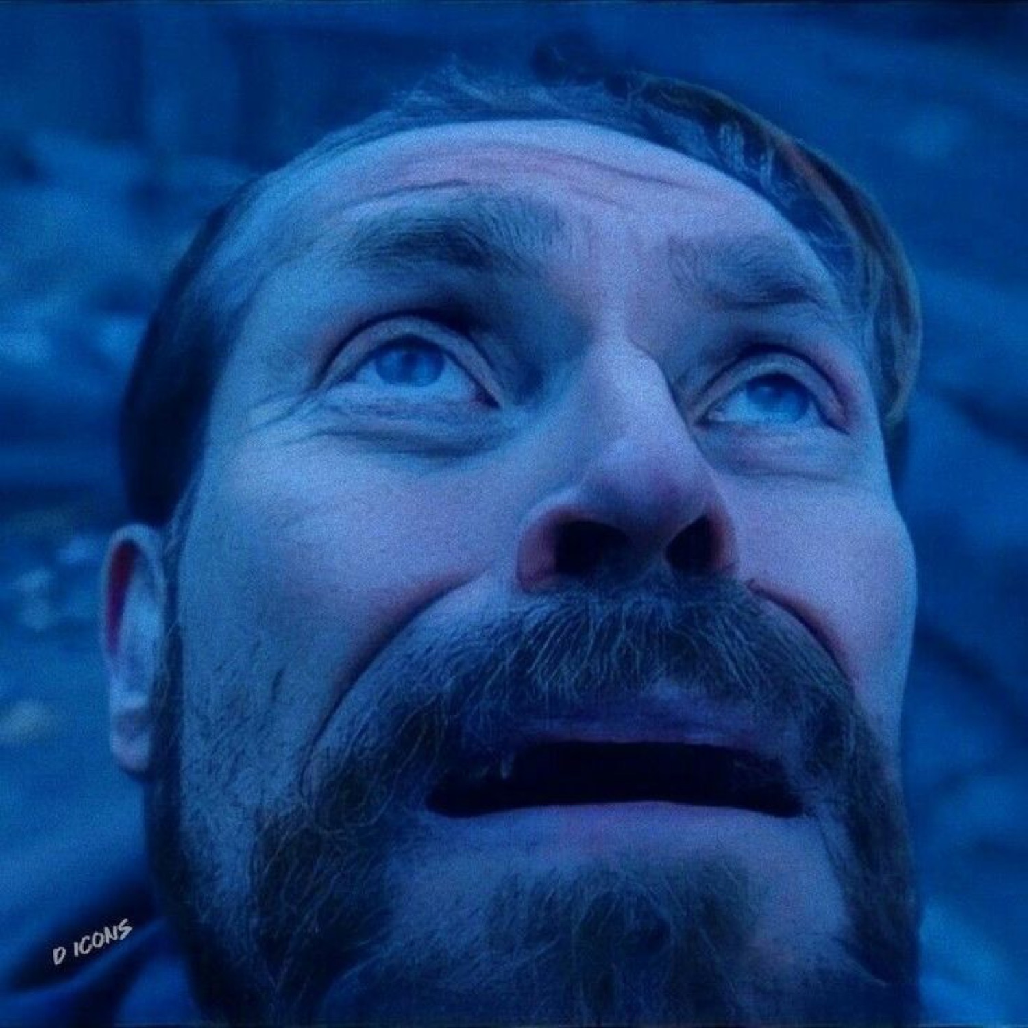 Man gazing upward in awe with wide eyes, bathed in intense blue light