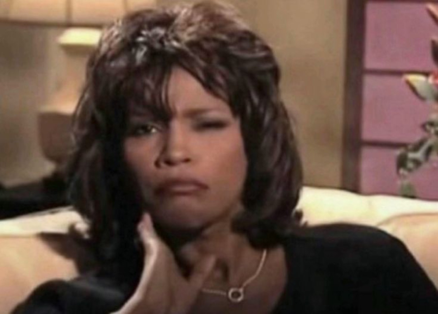 Whitney Houston with a perfectly sculpted unimpressed look, hand on neck, saying nothing and meaning everything