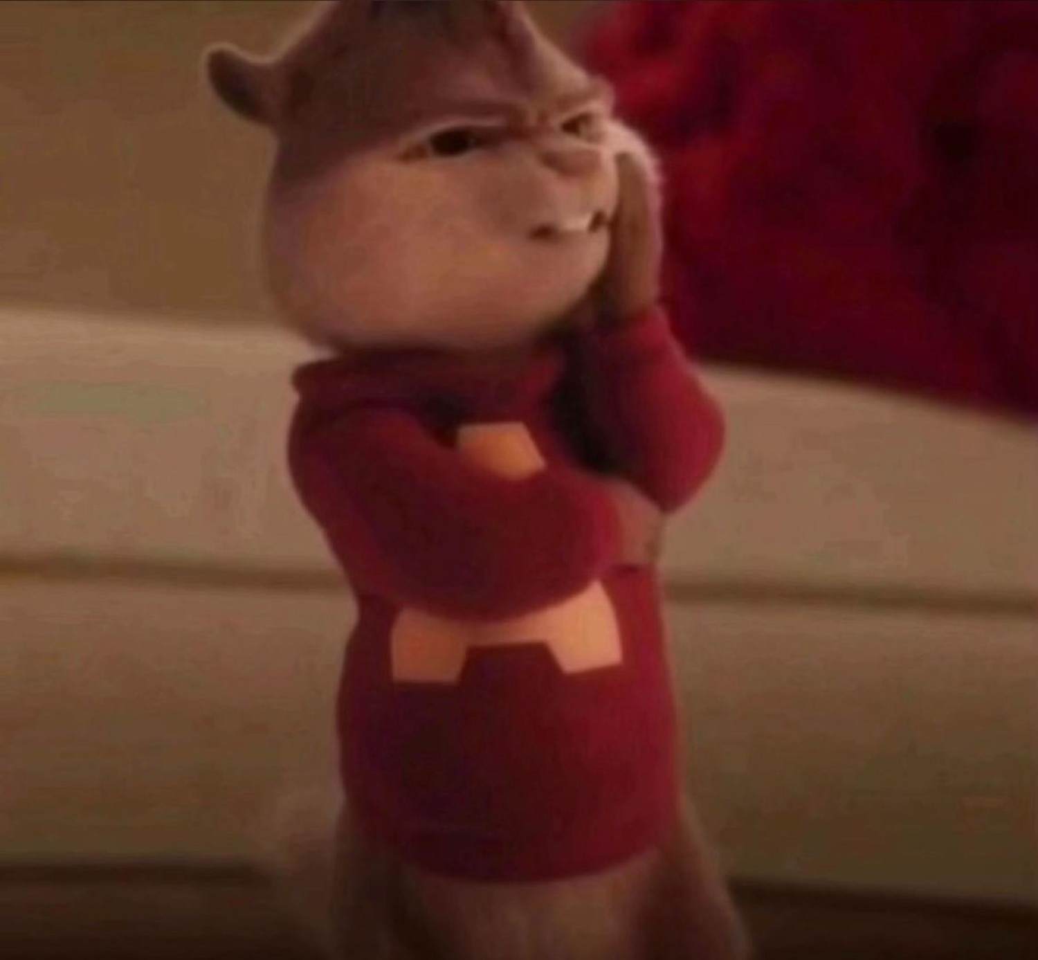 Alvin the Chipmunk in his red sweater pressing his fingertips together with a scheming face