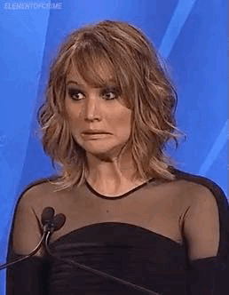 Jennifer Lawrence at a microphone pulling an awkward face
