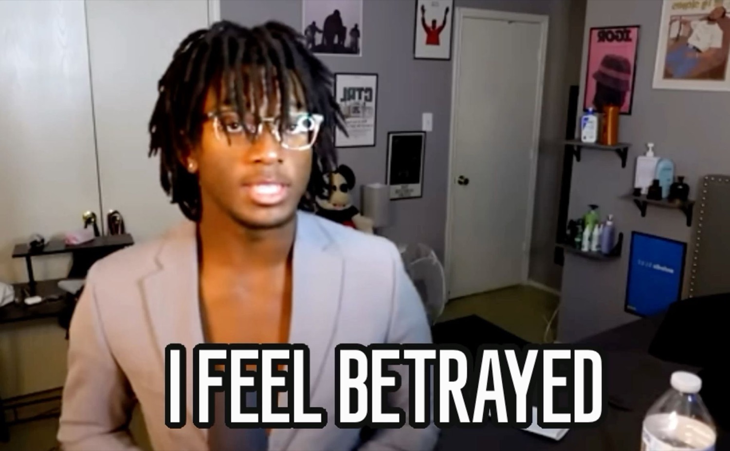 Young man in glasses staring at the camera, captioned 'I FEEL BETRAYED'