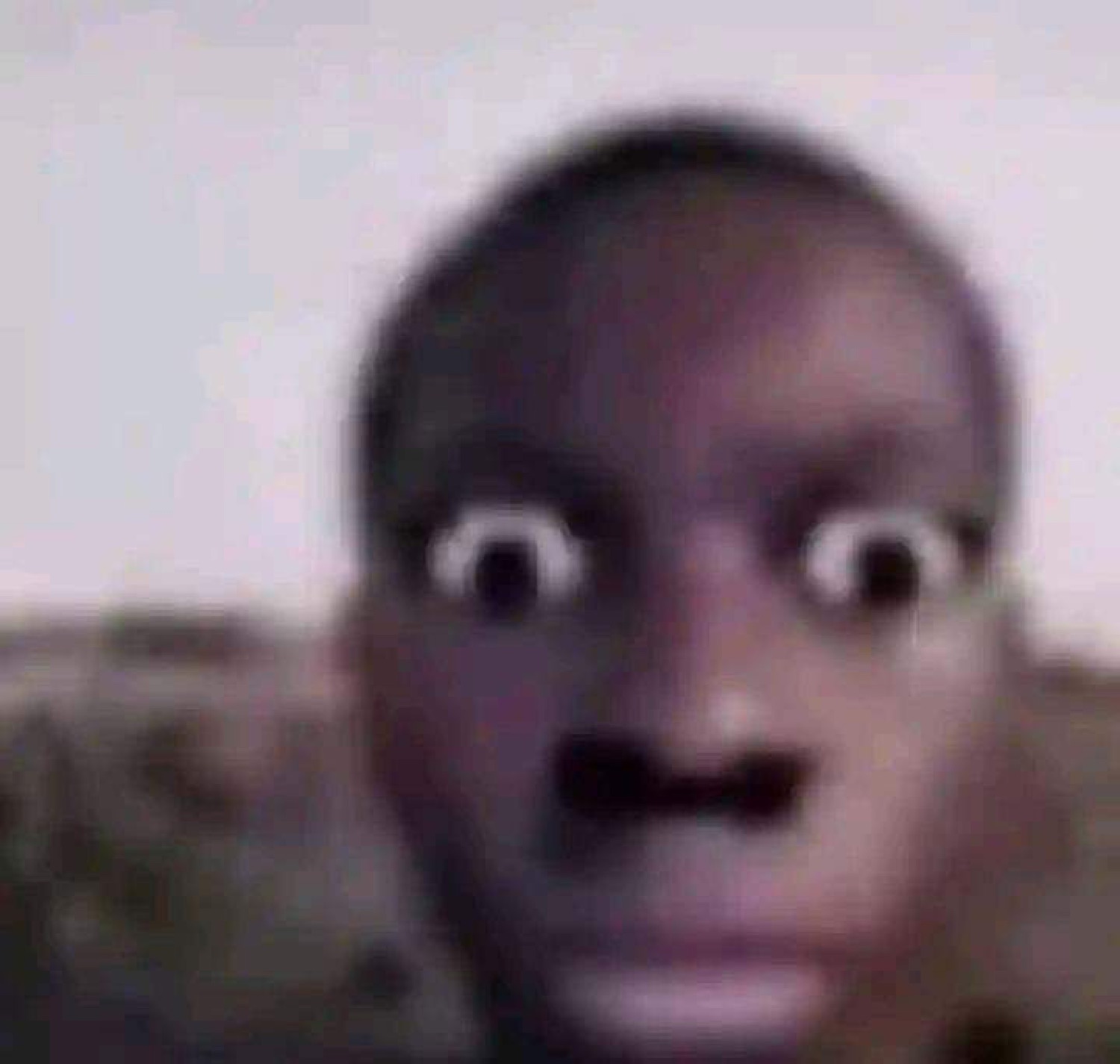 A blurry close-up of a person with eyes bugged out and mouth agape in total shock