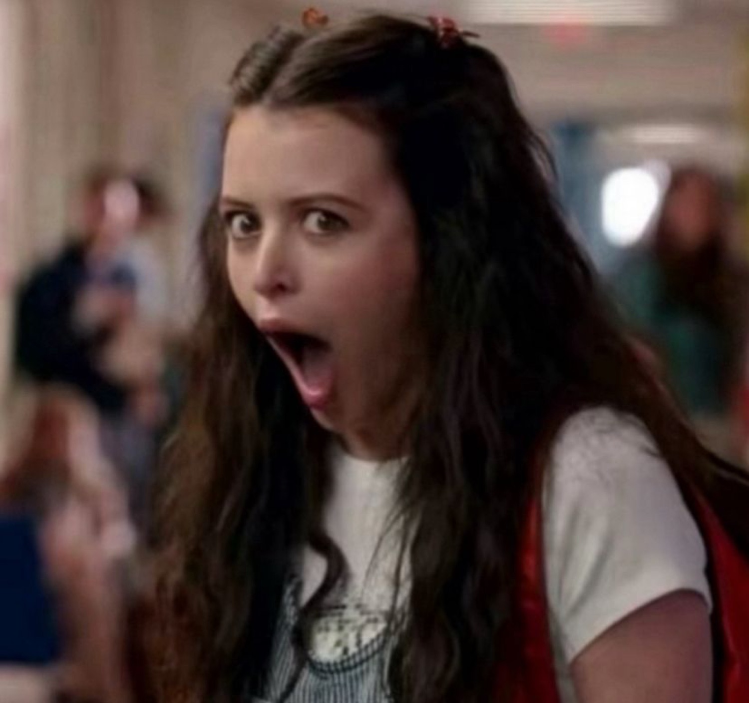 Teen girl in a school hallway with her jaw dropped in dramatic shock