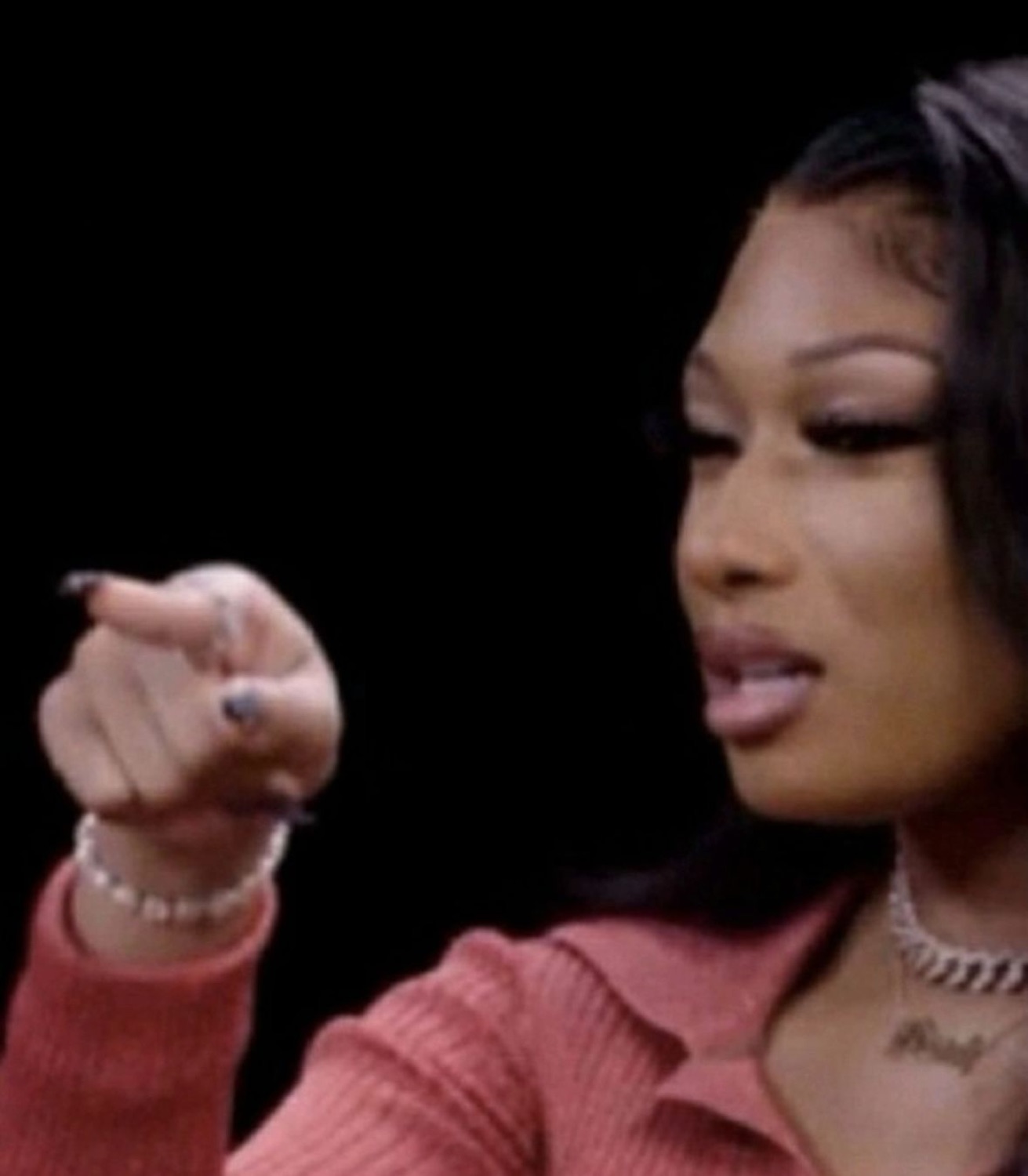Megan Thee Stallion pointing with a disgusted look