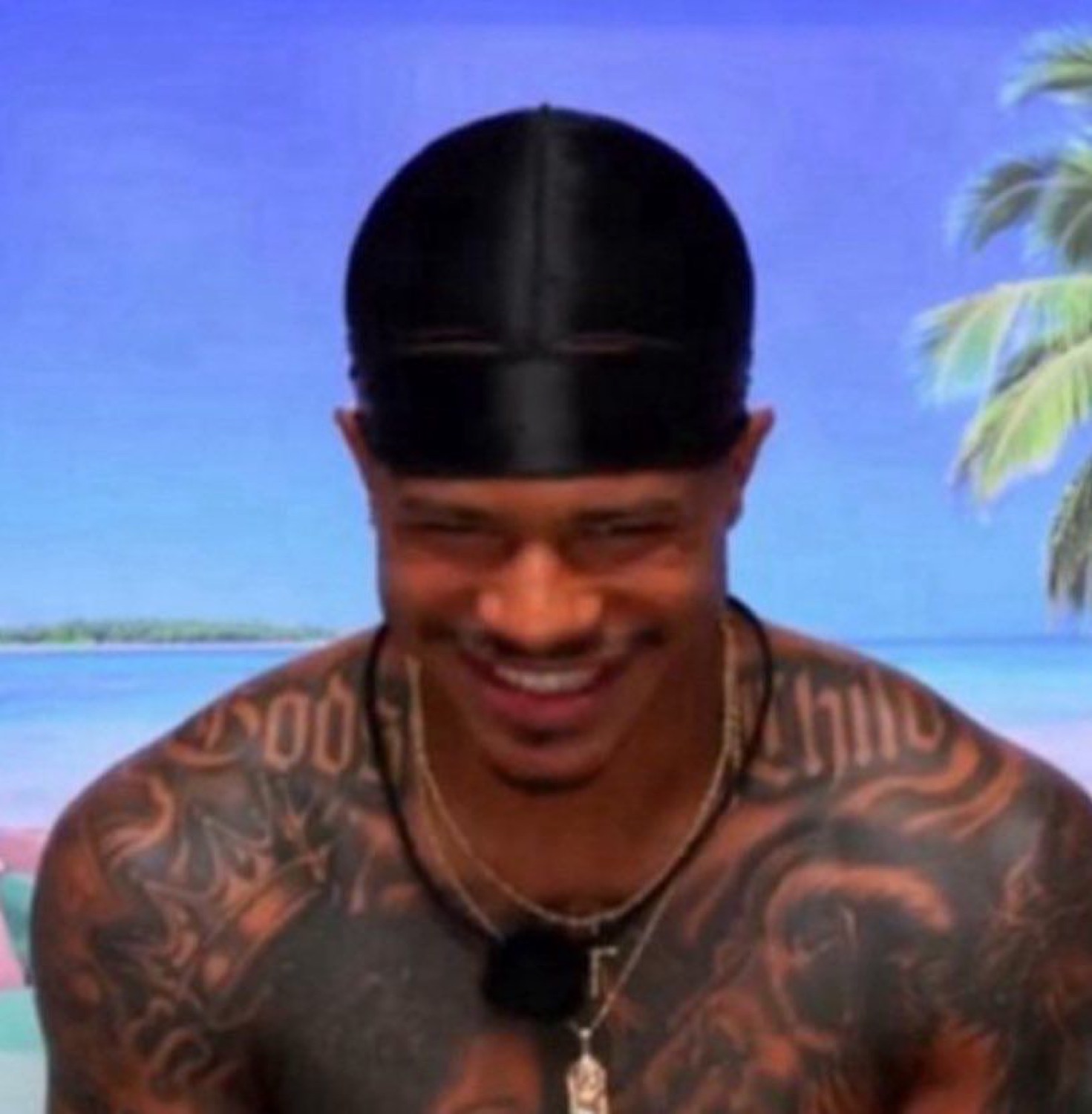 Love Island islander in a durag grinning mischievously