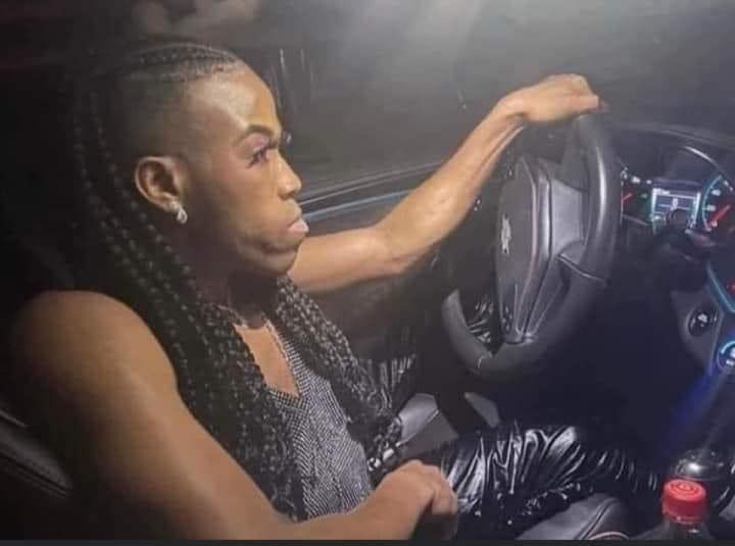 Woman with braids driving with a hard, focused stare