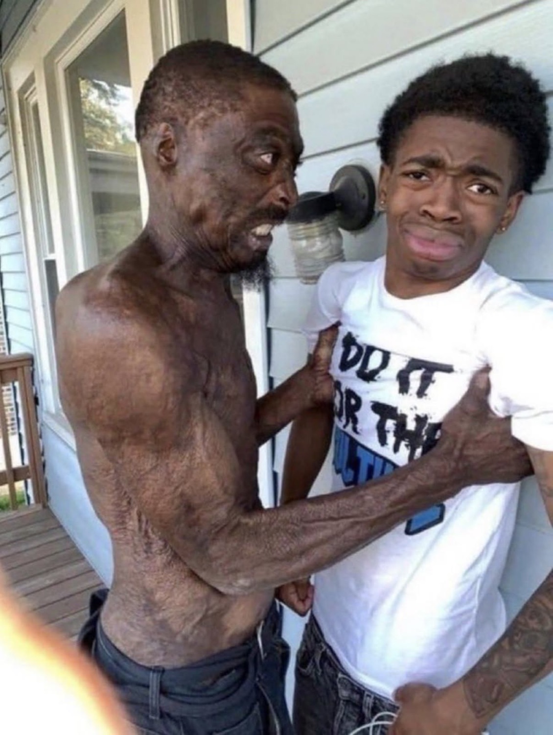 Older man grabbing a young guy's shirt aggressively while the younger man looks horrified