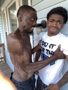 Older man grabbing a young guy's shirt aggressively while the younger man looks horrified