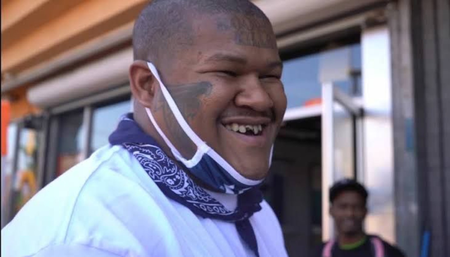 Crip Mac grinning big with his mask pulled down