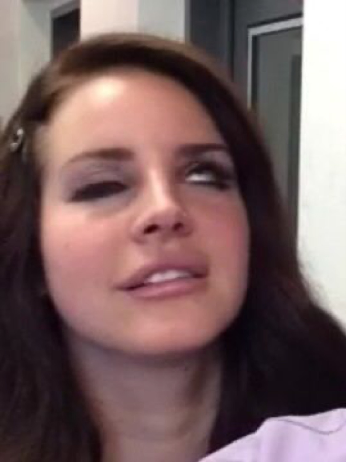 Lana Del Rey giving that classic barely-there smirk and distant gaze