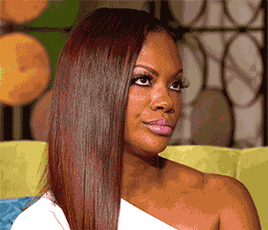 Woman with long straight hair slowly turning to give an unimpressed side glance