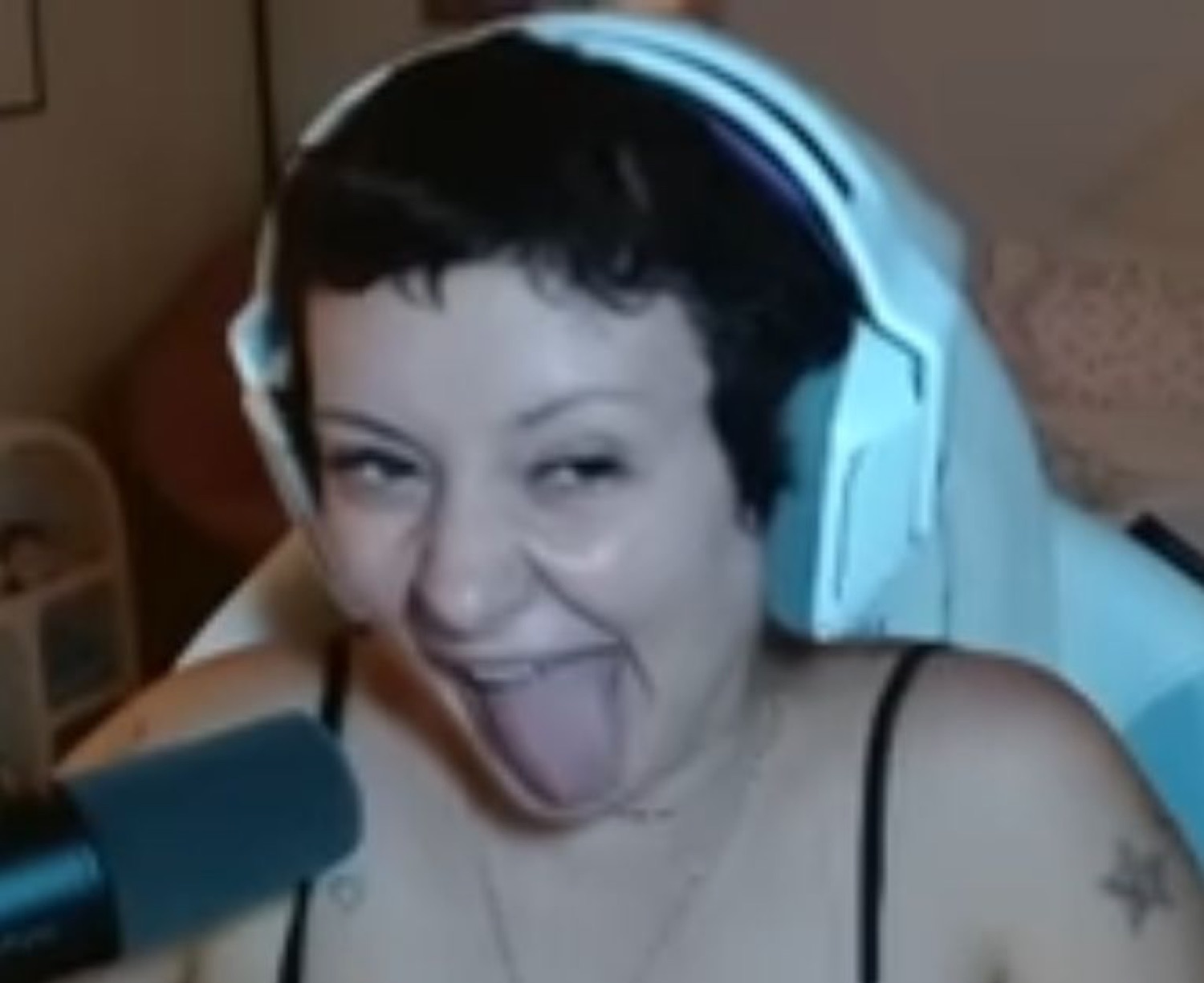 Streamer in gaming headset sticking her tongue out with a wild, goofy grin