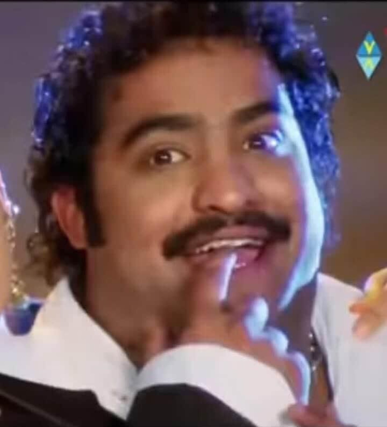 Man with a mustache coyly biting his finger