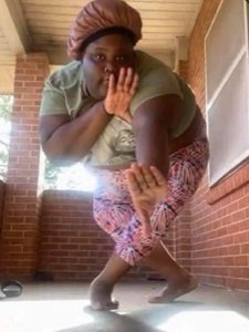 Woman in a bonnet crouching in shock on a porch with both hands covering her mouth