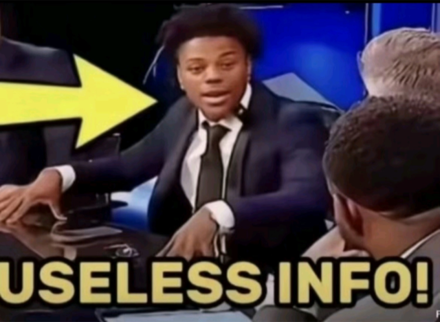Guy at a TV panel desk labeled 'USELESS INFO!' pointing away with an exasperated look