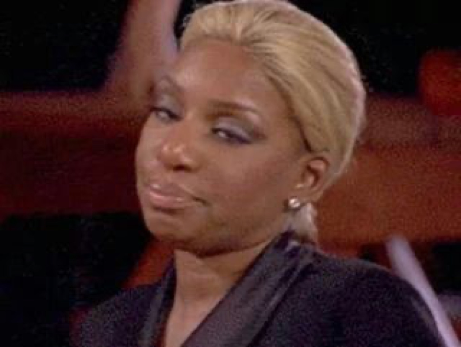 Woman with blonde hair giving a smug, unimpressed side-eye smirk