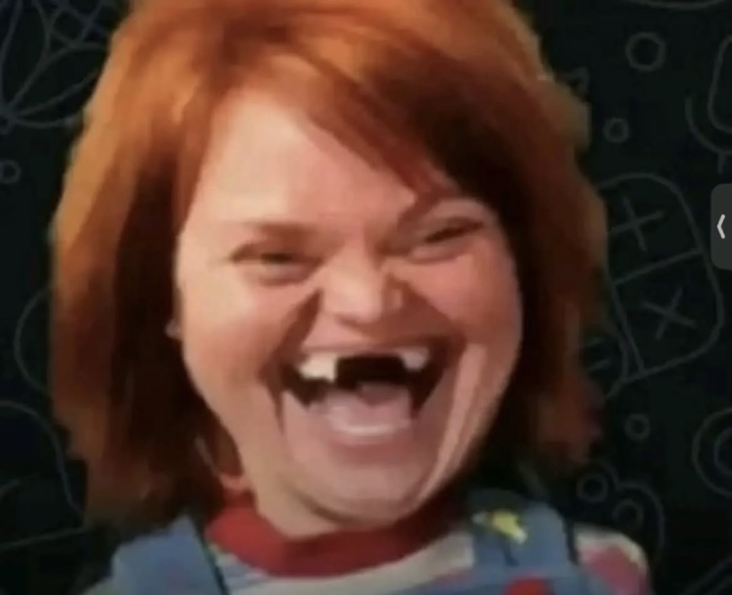 Chucky doll laughing maniacally with missing teeth and wild red hair