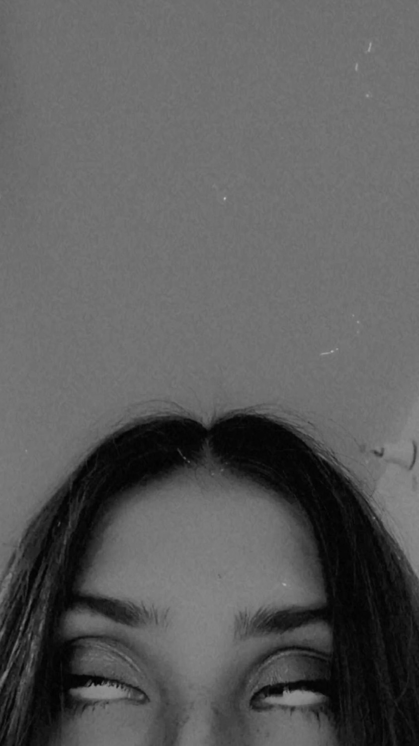 Black-and-white shot of a woman rolling her eyes all the way back, only the top of her face visible