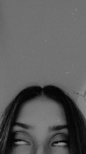 Black-and-white shot of a woman rolling her eyes all the way back, only the top of her face visible