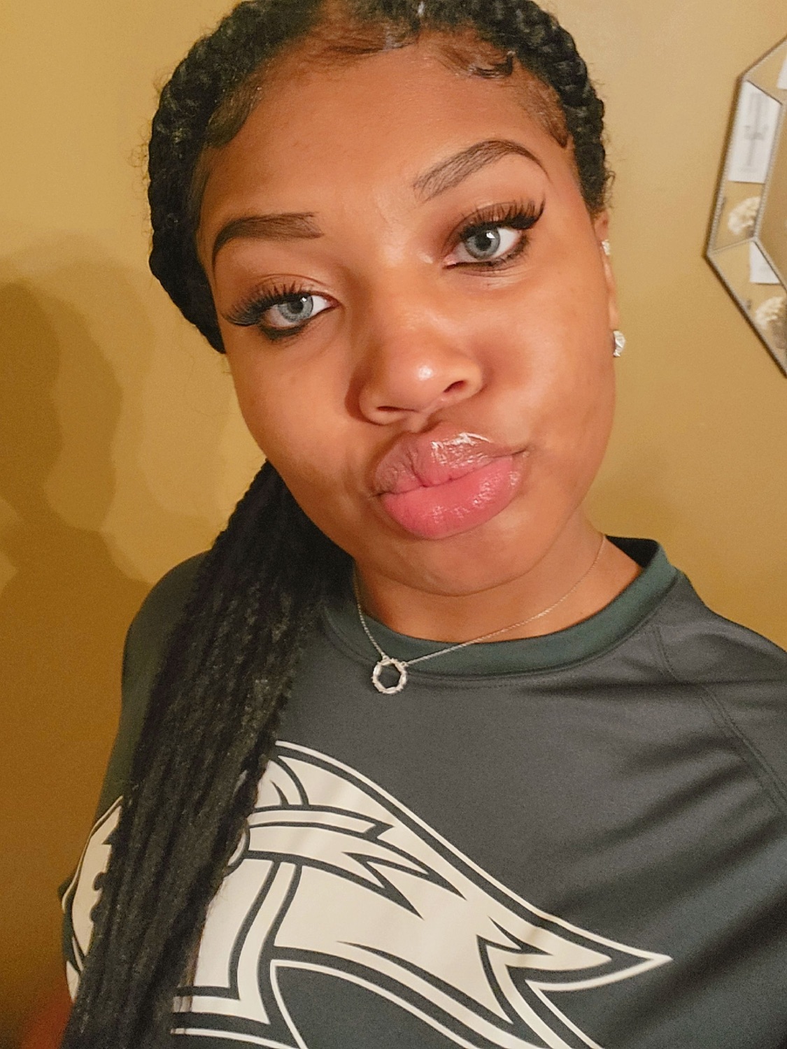 Selfie of a young woman in an Eagles shirt making a playful pout at the camera