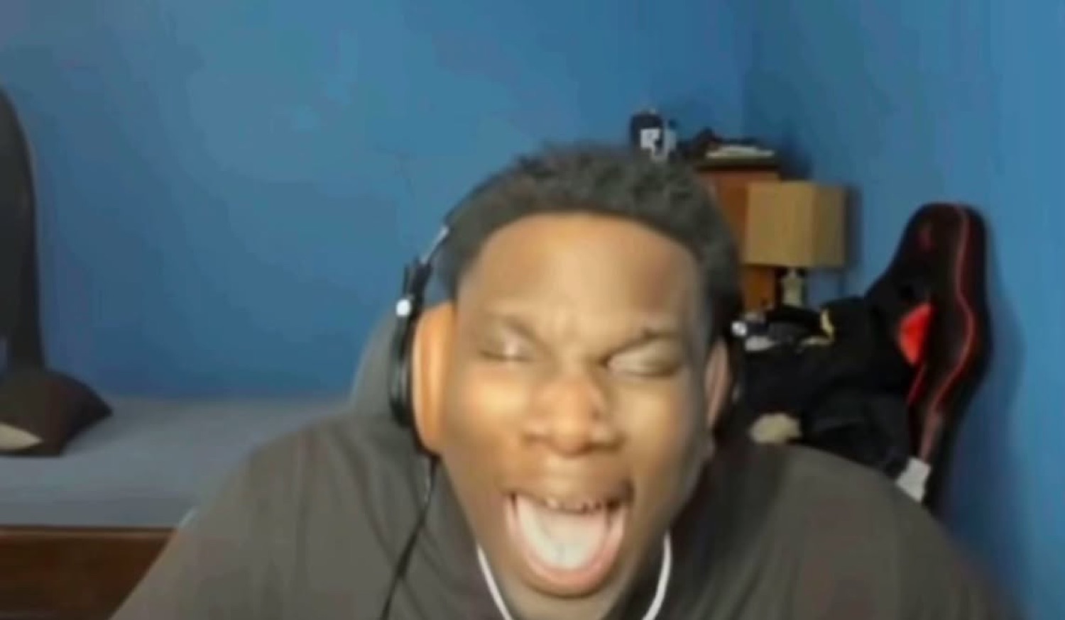 Guy in headphones cracking up mid-stream with his mouth wide open