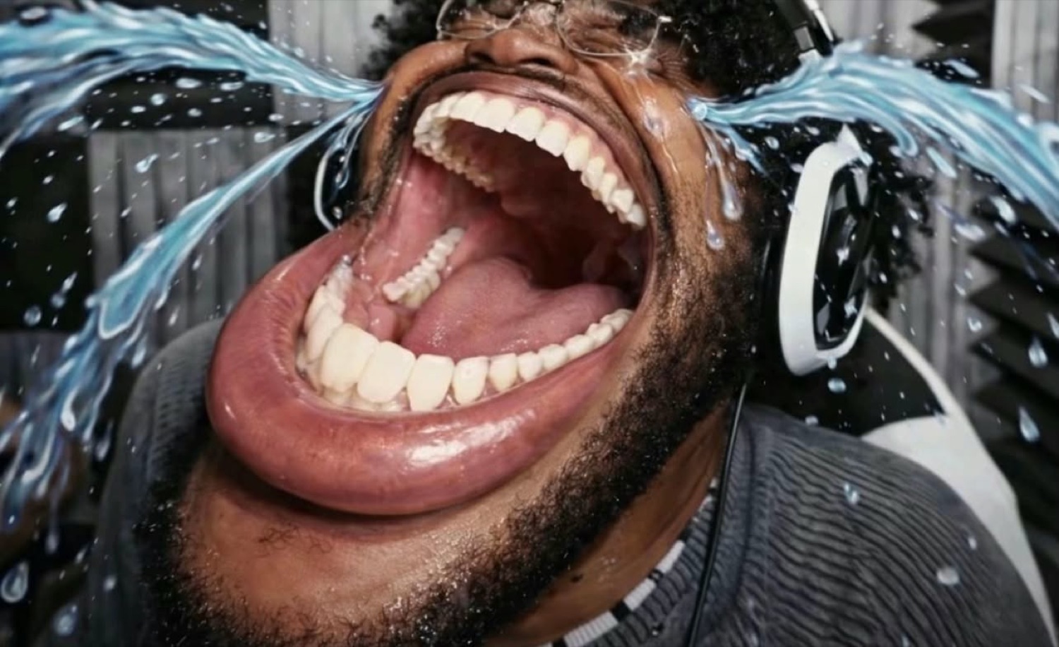 Man in headphones mouth stretched wide with cartoon tears blasting out from laughing so hard