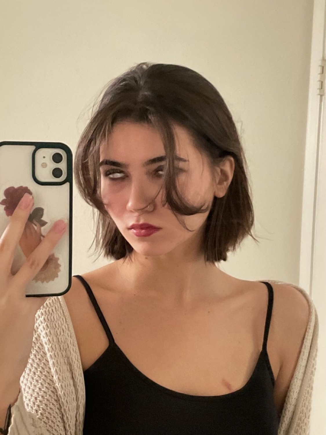 Woman taking a mirror selfie rolling her eyes back with a fed-up expression