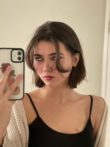 Woman taking a mirror selfie rolling her eyes back with a fed-up expression