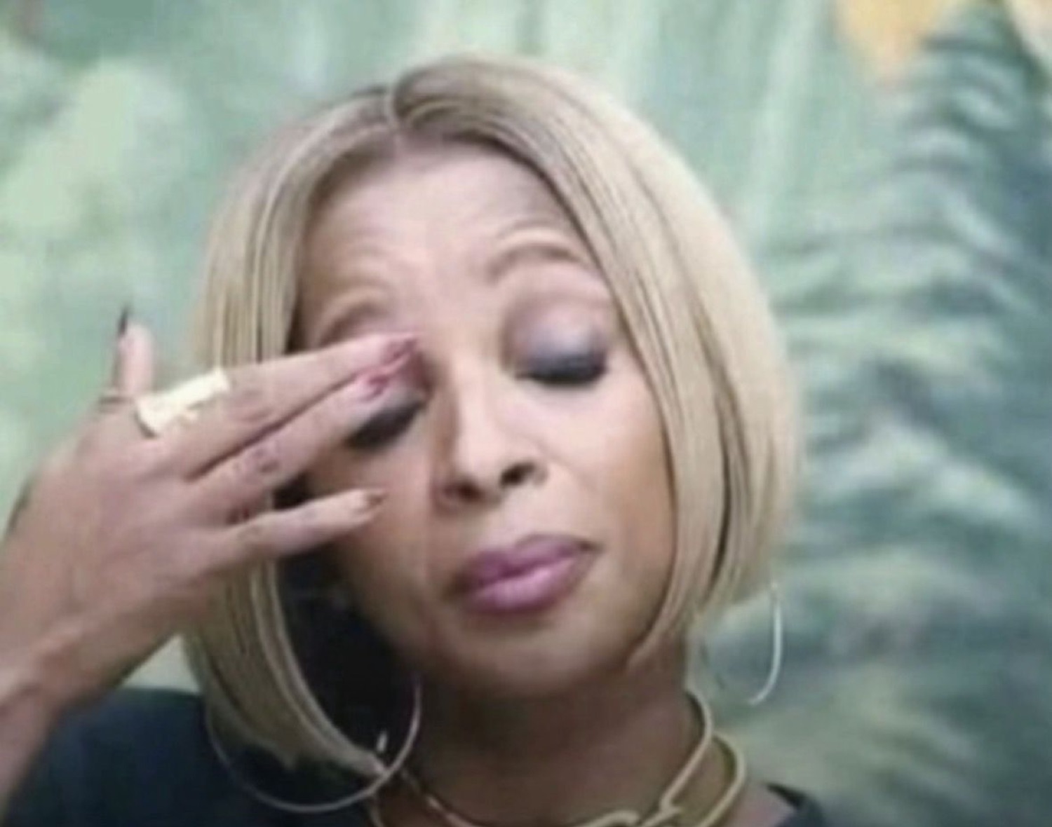 Woman with a blonde bob pressing her fingers to her eye, looking exhausted and let down
