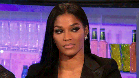 Woman slowly cutting a sharp, unimpressed side-eye at a bar