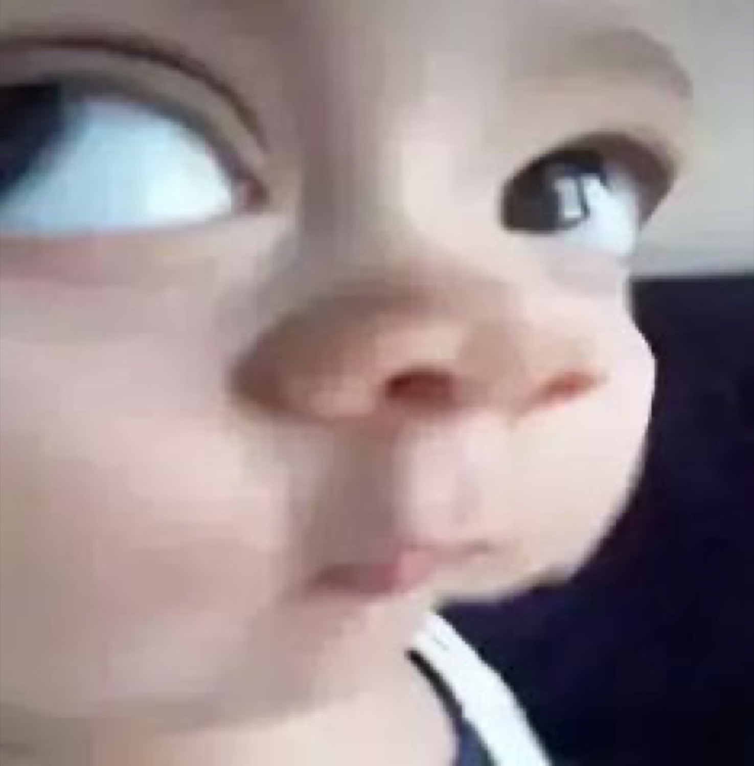 Extreme close-up of a baby's face giving a wonky, suspicious side-eye