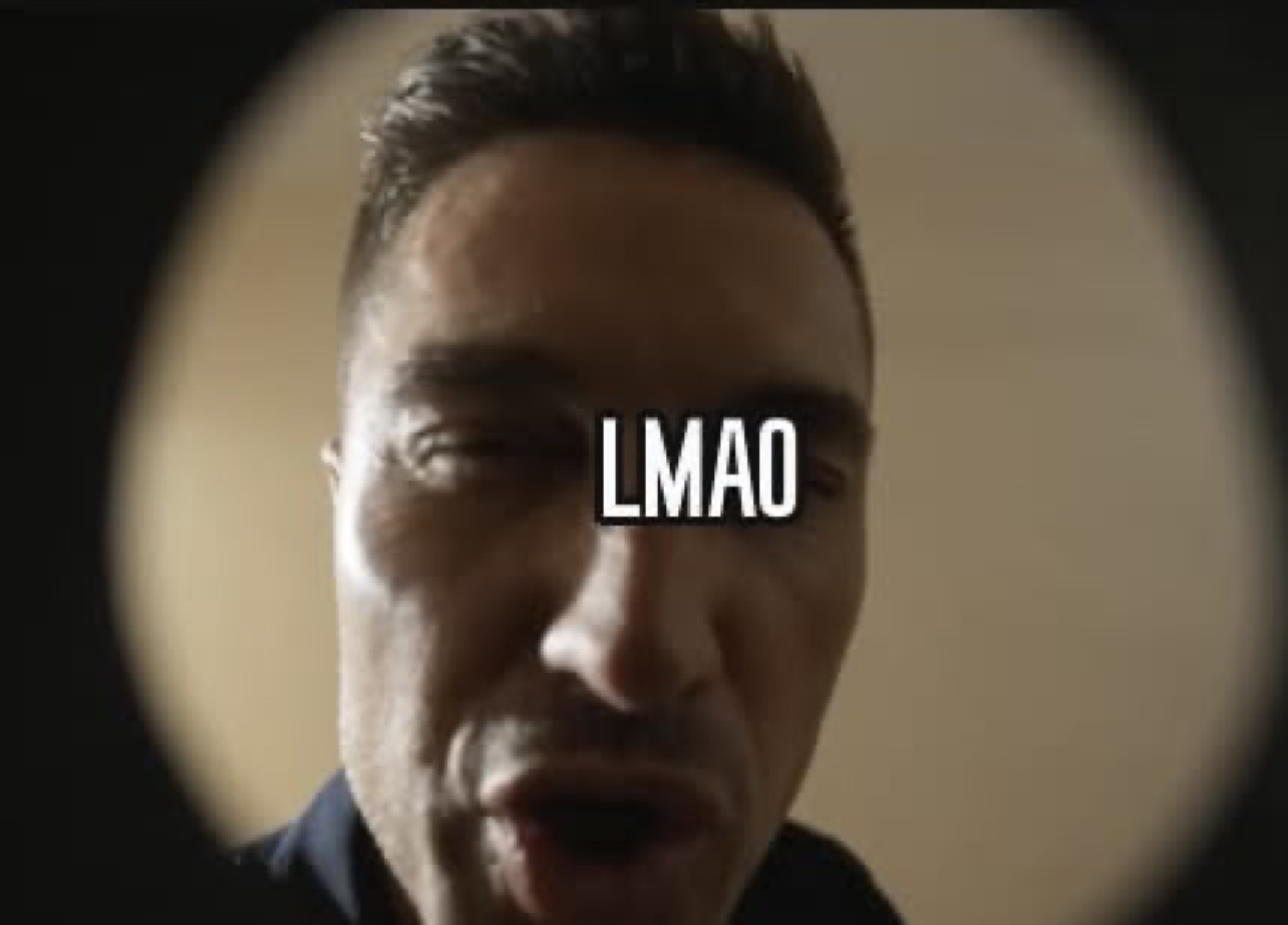 Man's face seen through a door peephole with 'LMAO'