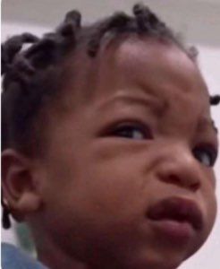 Baby with braids scrunching up their face in a deeply unimpressed, judgmental glare