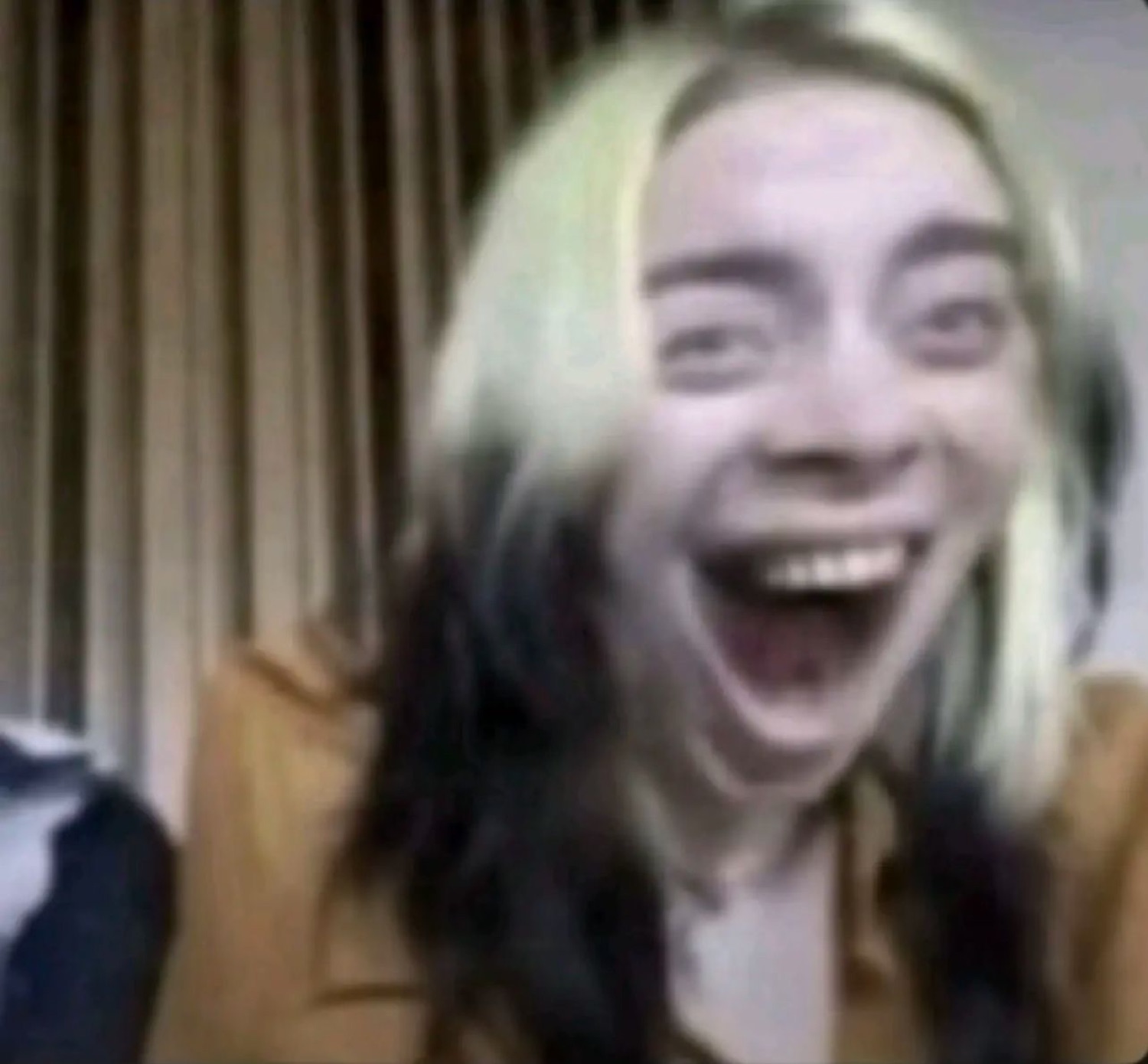 Grainy webcam shot of a young woman throwing her head back laughing hysterically