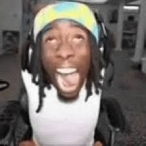 Guy with dreads and a headband screaming with his mouth wide open and eyes rolled back
