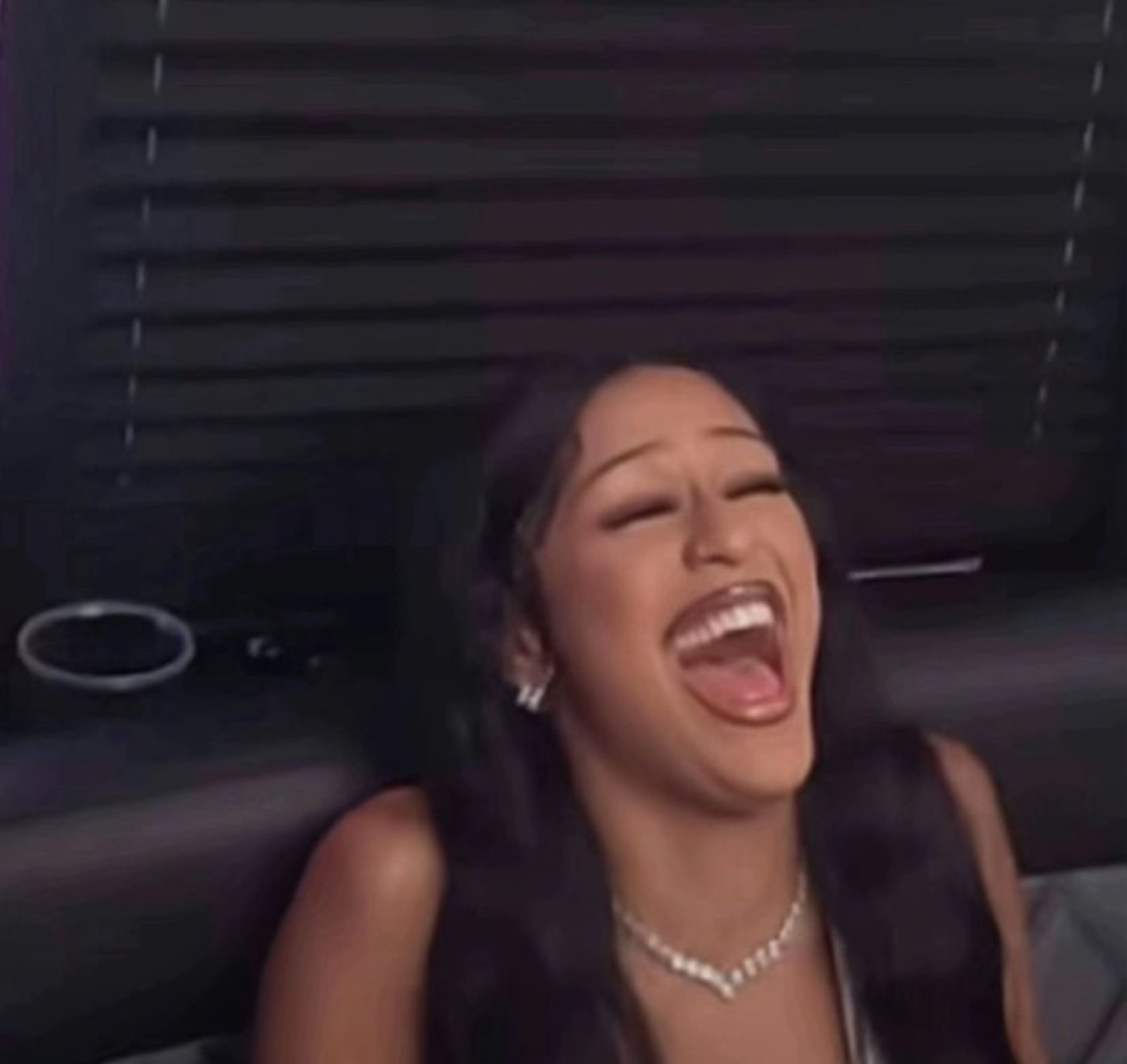 Woman throwing her head back laughing hard with her mouth wide open