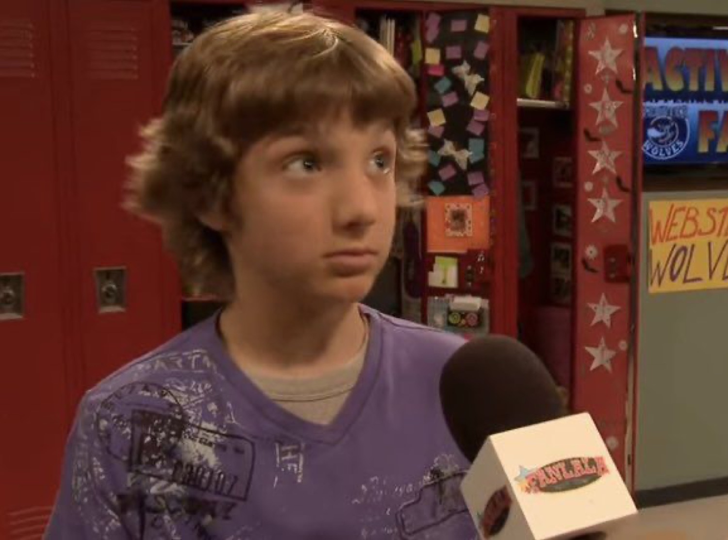 Kid in a purple shirt giving a skeptical side-eye during a hallway interview