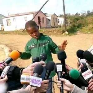 Man at a press mic swarm gesturing while explaining himself to reporters