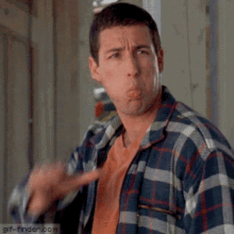 Adam Sandler in a plaid shirt giving a big thumbs down
