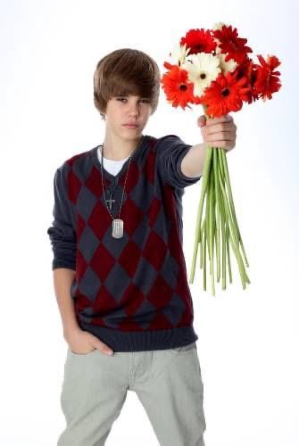 Young Justin Bieber holding out a bouquet of flowers with a deadpan face