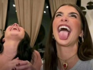 Two women cracking up, one throwing her head back laughing and the other sticking her tongue out