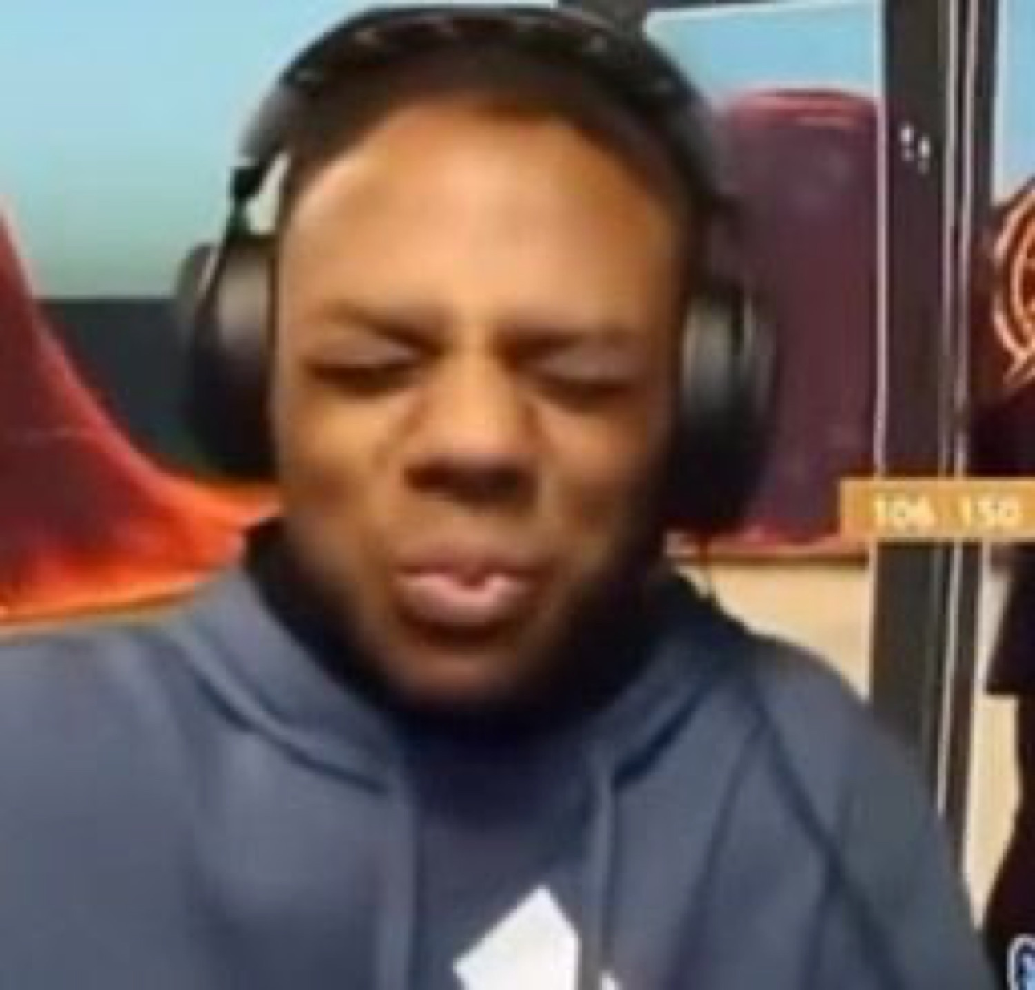 Guy in headphones squinting hard with his whole face scrunched in disgust or pain