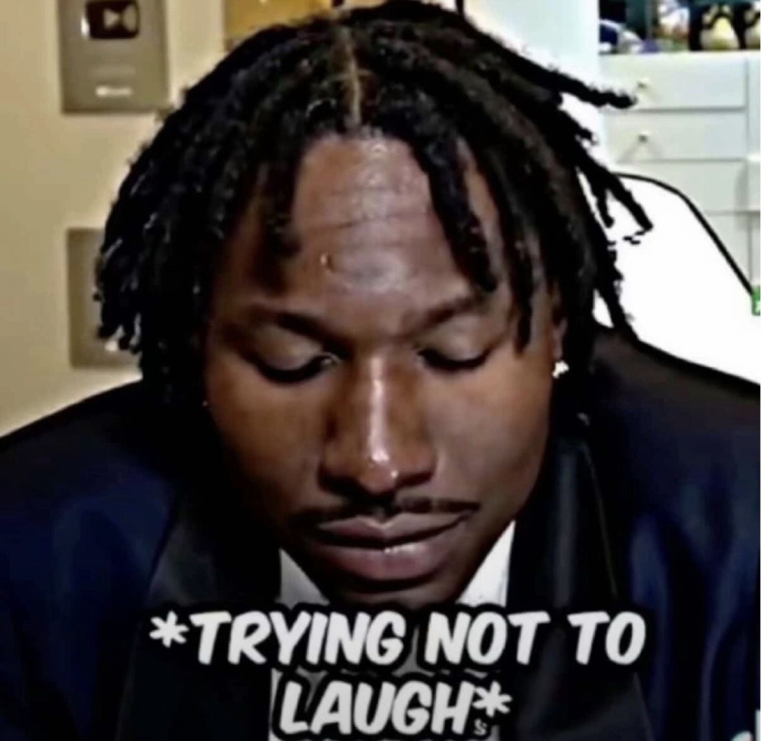 Man looking down and biting back a grin, captioned '*trying not to laugh*'